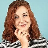 Smiling woman with curly hair on blue background