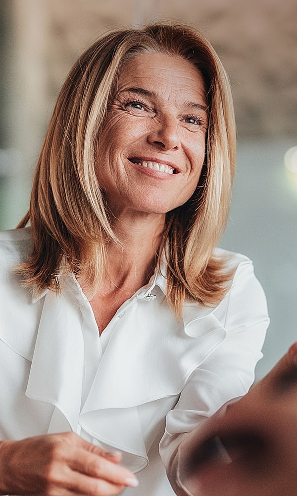 Smiling woman with long hair in white blouse